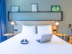 a bedroom with a bed with a laptop on it at Hotel ibis Bragança in Bragança