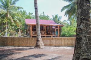 a house with a palm tree in front of it at Toro Simalatcat Surfcamp in Masokut