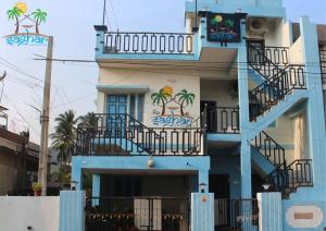 un edificio azul con un balcón con palmeras. en Saghar House en Visakhapatnam