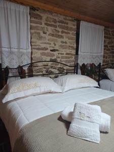 a large white bed with two white towels on it at Guest House Hasko in Gjirokastër