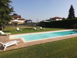 a swimming pool with two lawn chairs and umbrellas at Villa azalea in Induno Olona