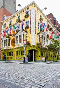 Un edificio amarillo con muchas banderas. en Gogartys Temple Bar Apartments, en Dublín