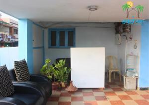 a living room with a couch and a white wall at Saghar House in Visakhapatnam