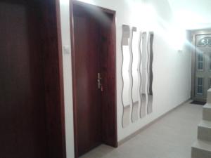 a door with three abstract drawings on the wall at Guest House Dimitrije in Niška Banja