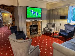 a living room with a television and a fireplace at The Angel Hotel in Alton