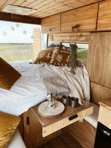 a bed in an rv with a table at The Feather Van in Puerto del Rosario