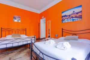 Duas camas num quarto com uma parede laranja em Vatican Apartments 1-2 em Roma
