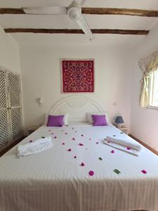 una camera da letto con un letto bianco e fiori di Villa Yasmin a Watamu