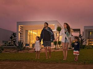une famille debout devant une maison dans l'établissement Sofitel Tamuda Bay Beach And Spa, à M'diq