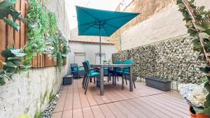 a table and chairs with a blue umbrella on a patio at Almada Apartments 468 in Porto