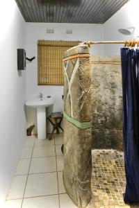 a bathroom with a sink and a large rock at Leopards Ledge in Nelspruit