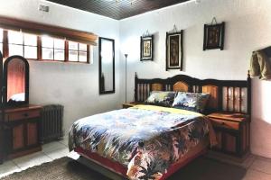 a bedroom with a bed with a wooden head board at Leopards Ledge in Nelspruit