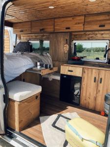 uma vista interior de uma caravana com uma cama e uma lareira em The Feather Van em Puerto del Rosario