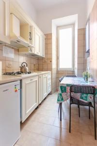 uma cozinha com armários brancos e uma mesa com cadeiras em Vatican Apartments 1-2 em Roma
