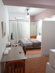 a bedroom with a bed and a table and a dining room at VASO'S APPARTMENTS A in Missolonghi