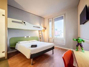 a hotel room with a bed with a superhero figure on it at ibis budget Frankfurt City Ost in Frankfurt