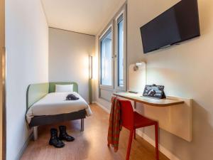 Zimmer mit einem Bett, einem Schreibtisch und einem TV in der Unterkunft ibis budget Frankfurt City Ost in Frankfurt am Main