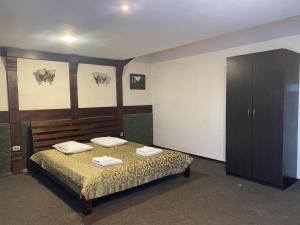 1 dormitorio con 1 cama con 2 toallas en Viktoria Hotel en Obroshino