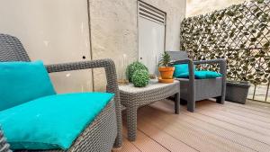 un patio con sillas de mimbre y una mesa con plantas en Almada Apartments 468, en Oporto