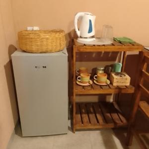 a small refrigerator next to a shelf with a tea kettle at El Aromito Hospedaje in Tilcara