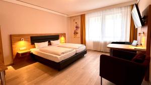 ein Hotelzimmer mit einem Bett und einem Schreibtisch in der Unterkunft Hotel Gute Hoffnung Pforzheim in Pforzheim