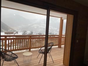 a balcony with two chairs and a table on a deck at L'Eden Roc in Saint-Jean-d'Aulps