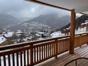 a balcony with a view of a snow covered mountain at L'Eden Roc in Saint-Jean-d'Aulps