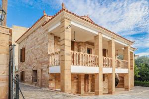 un grande edificio in mattoni con balcone di Archontiko Frideriki Luxury Apartments a Chio (Chios)