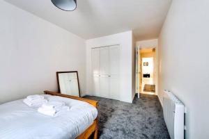 a white bedroom with a bed with towels on it at GuestReady - A Pleasant Stay near Leif in Edinburgh
