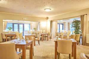 un restaurante con mesas y sillas y una gran ventana en Wensum Valley Hotel Golf and Country Club en Norwich
