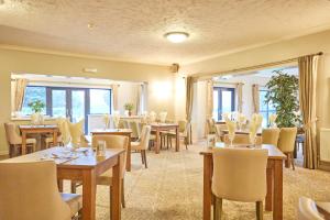 a restaurant with tables and chairs and a large window at Wensum Valley Hotel Golf and Country Club in Norwich