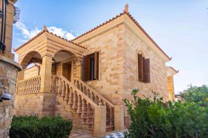 ein großes Backsteingebäude mit einer Treppe drauf in der Unterkunft Archontiko Frideriki Luxury Apartments in Chios