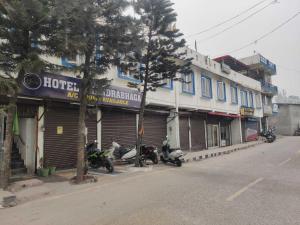 a street with motorcycles parked in front of a hotel at OYO Hotel Chandrabhaga in Rishīkesh