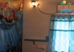 a bathroom with a shower curtain and a painting on the wall at Saghar House in Visakhapatnam