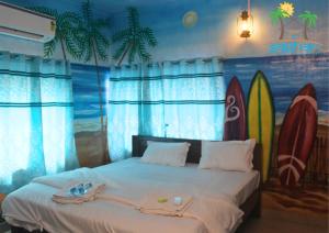 a bedroom with a bed with surfboards painted on the wall at Saghar House in Visakhapatnam