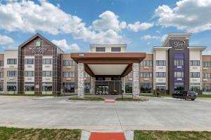 a large building with a parking lot in front of it at MainStay Suites Waukee-West Des Moines in Waukee