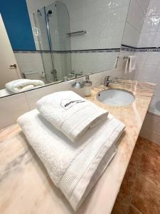 a bathroom with a sink and towels on a counter at Acogedor alojamiento en Martinet, Cerdanya. in Martinet