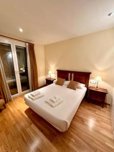 1 dormitorio con 1 cama blanca grande y 2 mesas en Acogedor alojamiento en Martinet, Cerdanya., en Martinet
