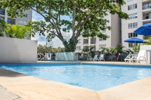 uma piscina num hotel com cadeiras e guarda-sóis em Apartamento con vistas en Cali 