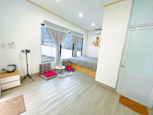 ein Schlafzimmer mit einem Bett und einem großen Fenster in der Unterkunft MỘC CHÂU HOUSE in Mộc Châu