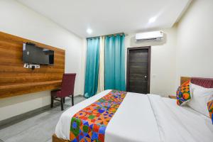 a bedroom with a bed and a desk and a tv at Hotel HC Dream Majestic in Mohali