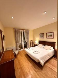 1 dormitorio con 1 cama grande y suelo de madera en Acogedor alojamiento en Martinet, Cerdanya., en Martinet