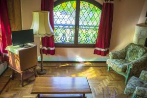 ein Wohnzimmer mit einem Tisch und einem Fenster in der Unterkunft Hotel Villino Della Flanella in Modena