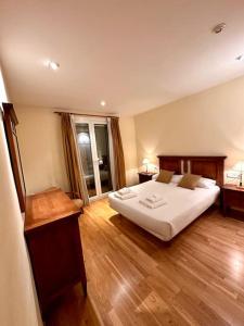 1 dormitorio con 1 cama blanca grande y suelo de madera en Acogedor alojamiento en Martinet, Cerdanya., en Martinet