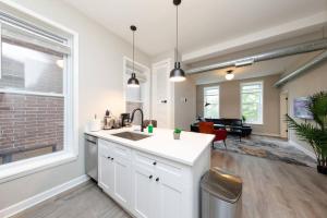 a kitchen with a sink and a living room at The Secret West Loop Oasis in Chicago