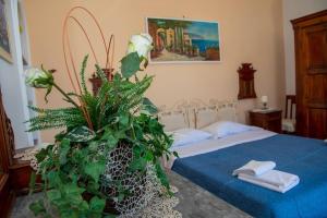 波西塔諾的住宿－M'incanto，一间卧室配有床和一个大植物