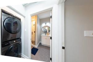 a laundry room with a washer and dryer and a mirror at The Secret West Loop Oasis in Chicago +9 photos