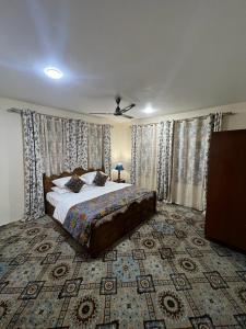 - une chambre avec un grand lit et un ventilateur de plafond dans l'établissement Garden of Eden resort, à Srinagar