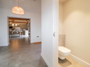 a bathroom with a toilet in the middle of a hallway at Lower Marsh Barns in Exeter