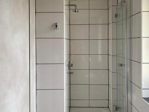 eine Dusche mit Glastüren im Bad in der Unterkunft Hotel Petite Königsallee SELF CHECK-IN in Düsseldorf